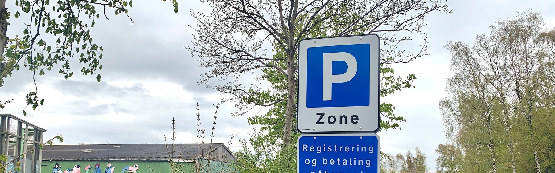 Skilt med tekst om reglerne for registrering af parkering på Musicons store p-pladser