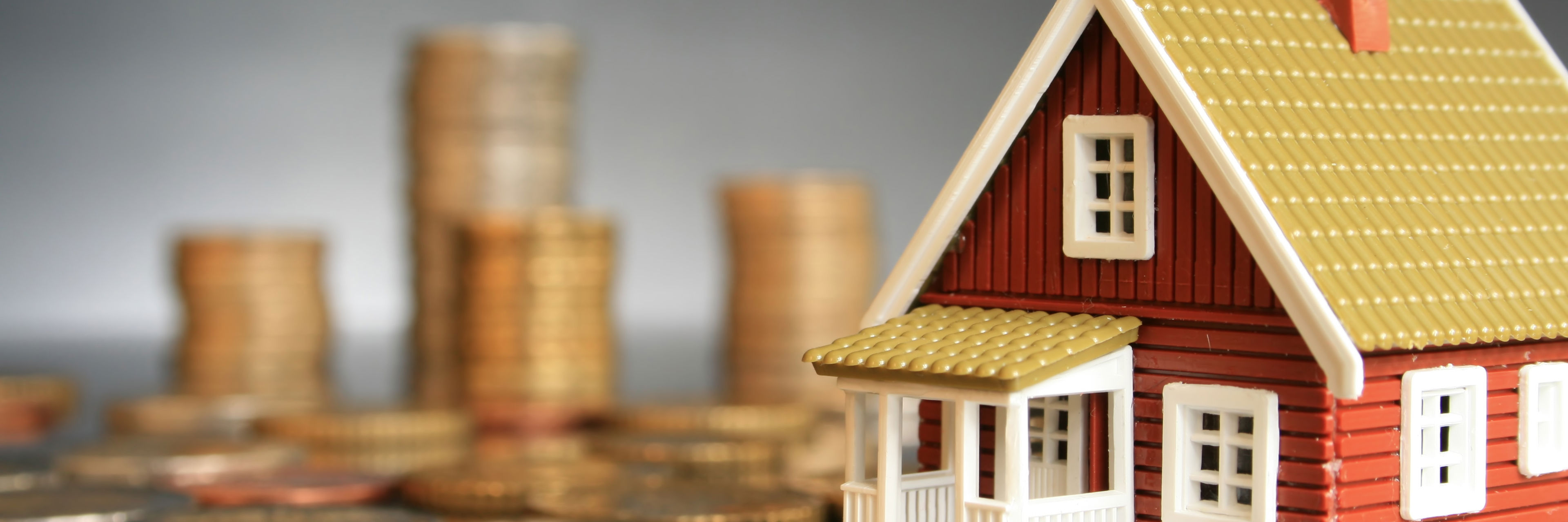 Billede af legetøjshus med store mønter omkring