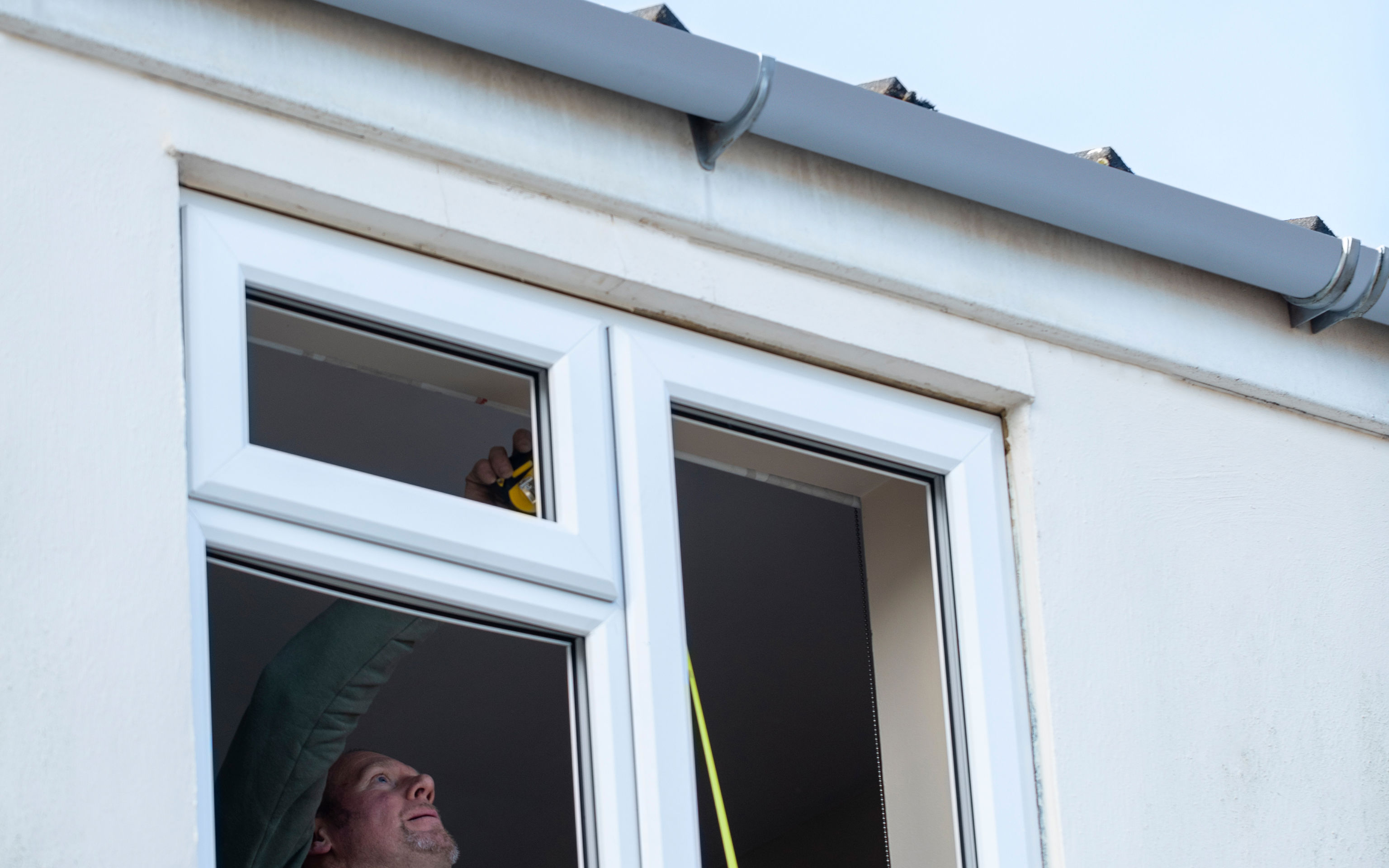 Mand opmåler vinduesparti for at energirenovere dem