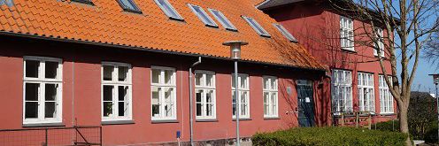 En rød bygning. Det er Alle Tiders Højskole.