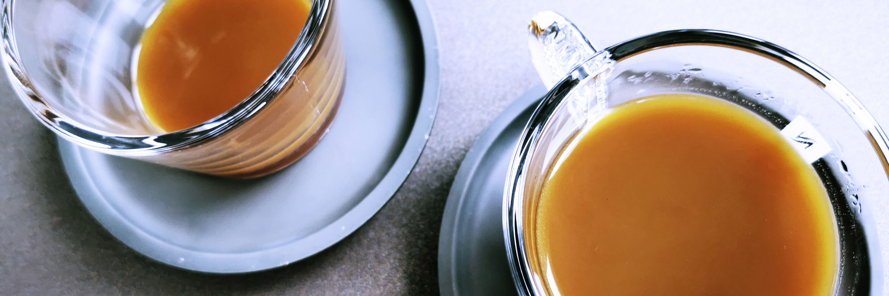 To kopper kaffe i glaskopper. Kaffen er lys - måske med mælk?