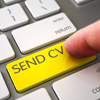 Person trykker på en knap på et tastatur. Knappen er gul, og der står "Send CV" på den.